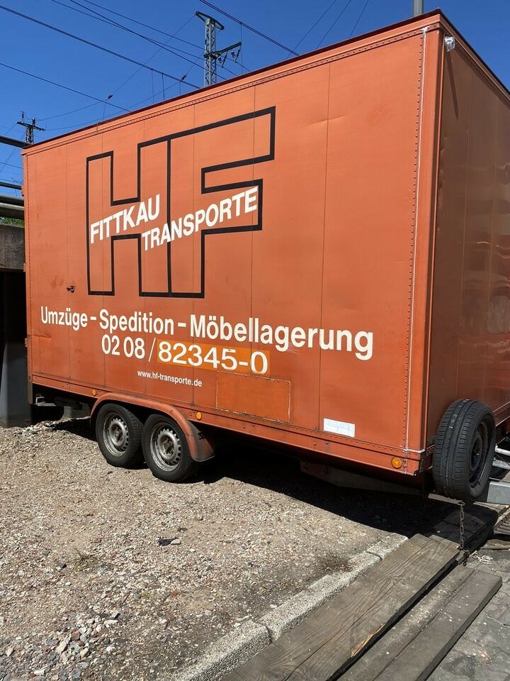 Orangefarbener Möbelkoffer-Anhänger von H.F. Transporte