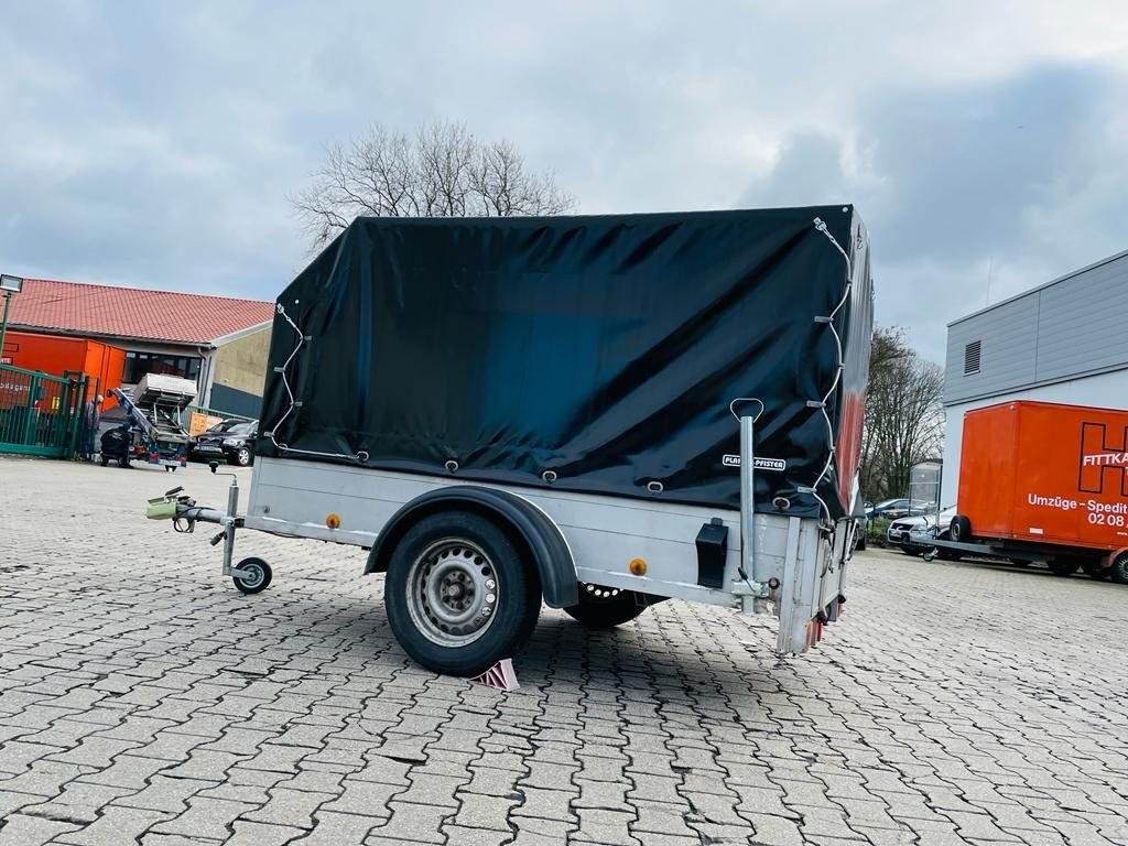 Kleiner Planenanhänger mit dunkler Plane auf dem Betriebshof von Umzüge Fittkau