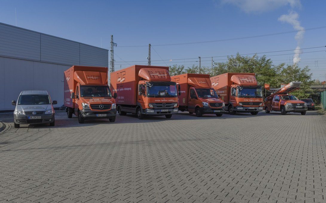 Umzugswagen und Lkw von Umzüge Fittkau in einer Reihe auf dem Betriebshof in Oberhausen